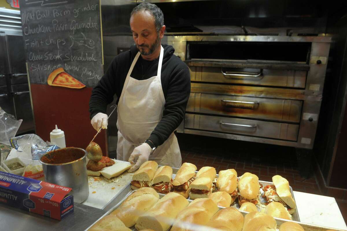 Claudio Sanfrancesco prepares chicken parmesan sandwiches in the kitchen at The Levee, a sports bar on the campus of Fairfield University. While the campus has been closed, Sanfranceso has been making hot meals and delivering them to area hospitals twice a week.
