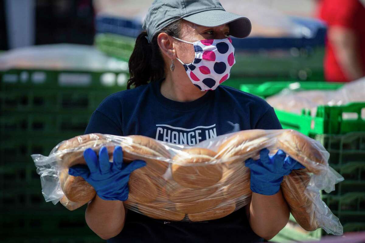 Elizabeth Davila holds a package of buns to give out during the April 24, 2020 San Antonio Food Bank drive thru food distribution at Toyota Field in San Antonio, Texas.