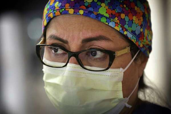 Alexsandra Morales, a nurse in Methodist Hospital’s COIVD-19 unit watches intensely as doctors work on a patient.
