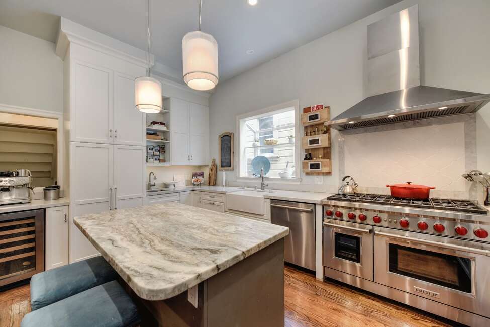 A gourmet kitchen is well-equipped for a family dishing out three meals a day. Cabinets reach to the top of the 10-foot ceiling, providing ample storage for food after big grocery store runs. A Wolf range has eight bunters and two ovens, plus the microwave can act as a convection oven. An island with a quartz countertop offers bar dining.