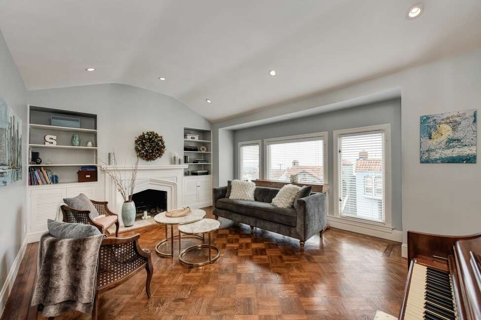The dining room flows into a light-filled living room with hardwood floors, a fireplace and high-coved ceiling.