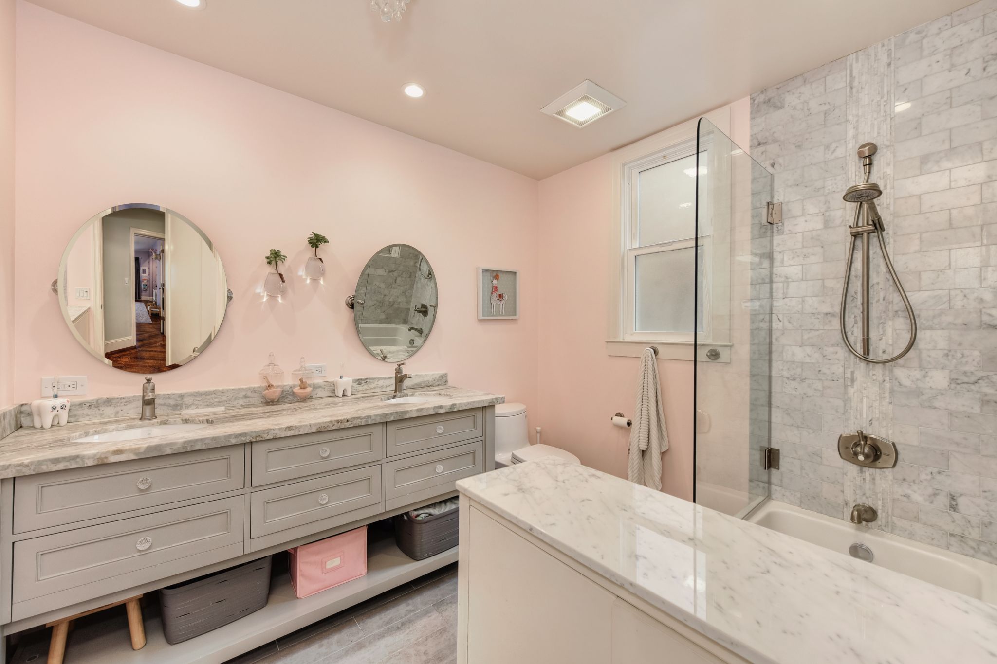 A bathroom with a shower tiled in marble is shared by the two other bedrooms.