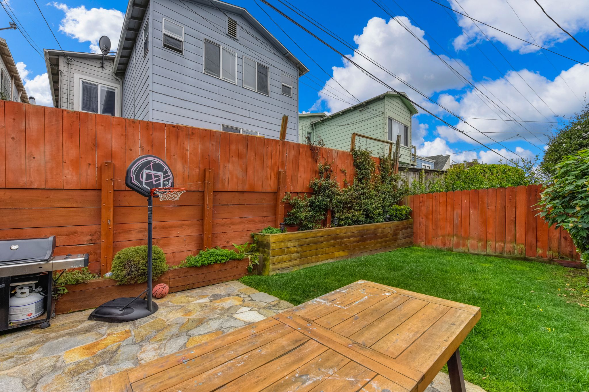 With a flagstone patio and a patch of grass, the backyard offers opportunities for outdoor play and dining.