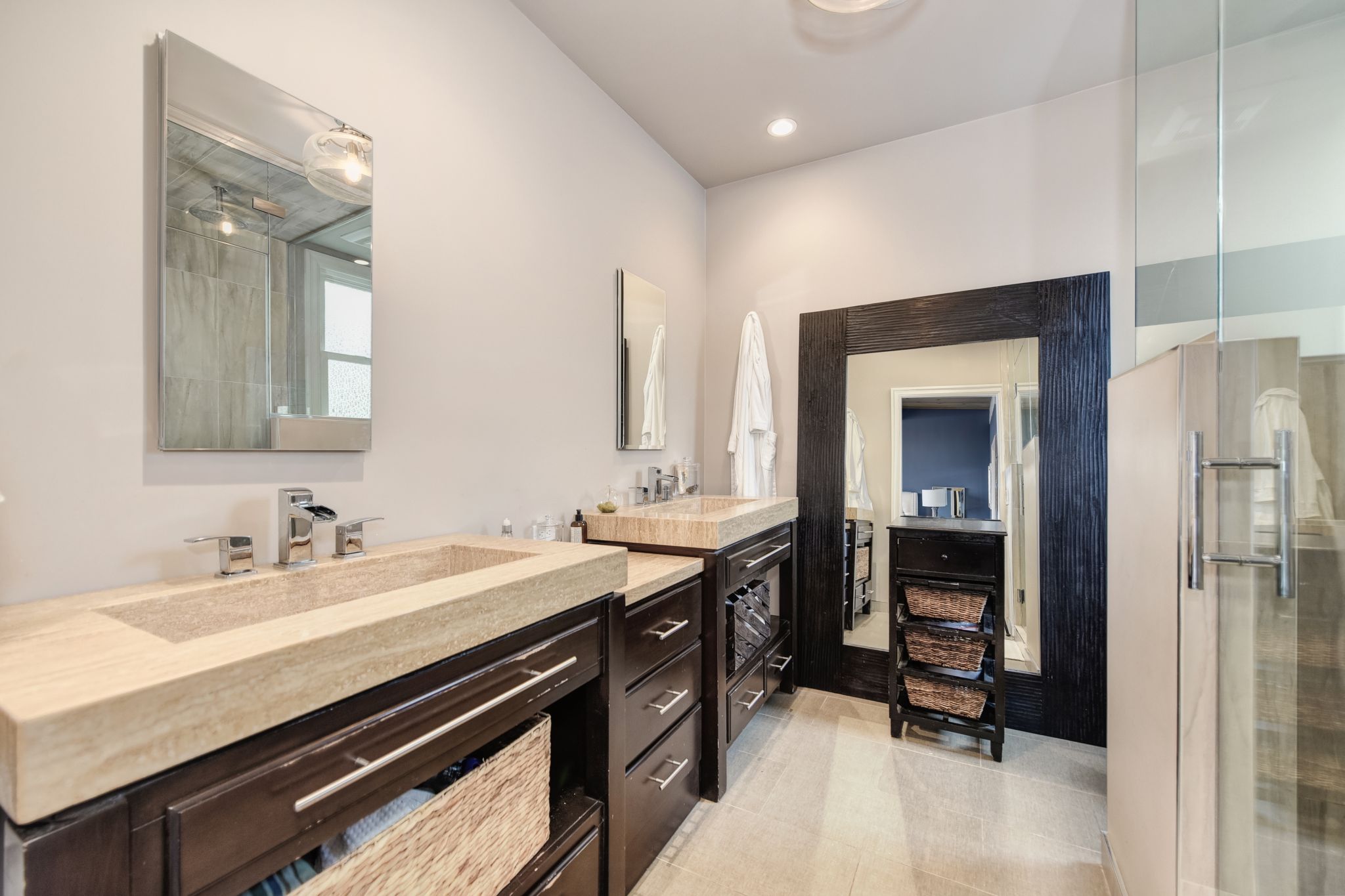 The master bedroom has its own en-suite bathroom with a double ramp sink in natural travertine with waterfall faucets. A walk-in shower has double shower heads.