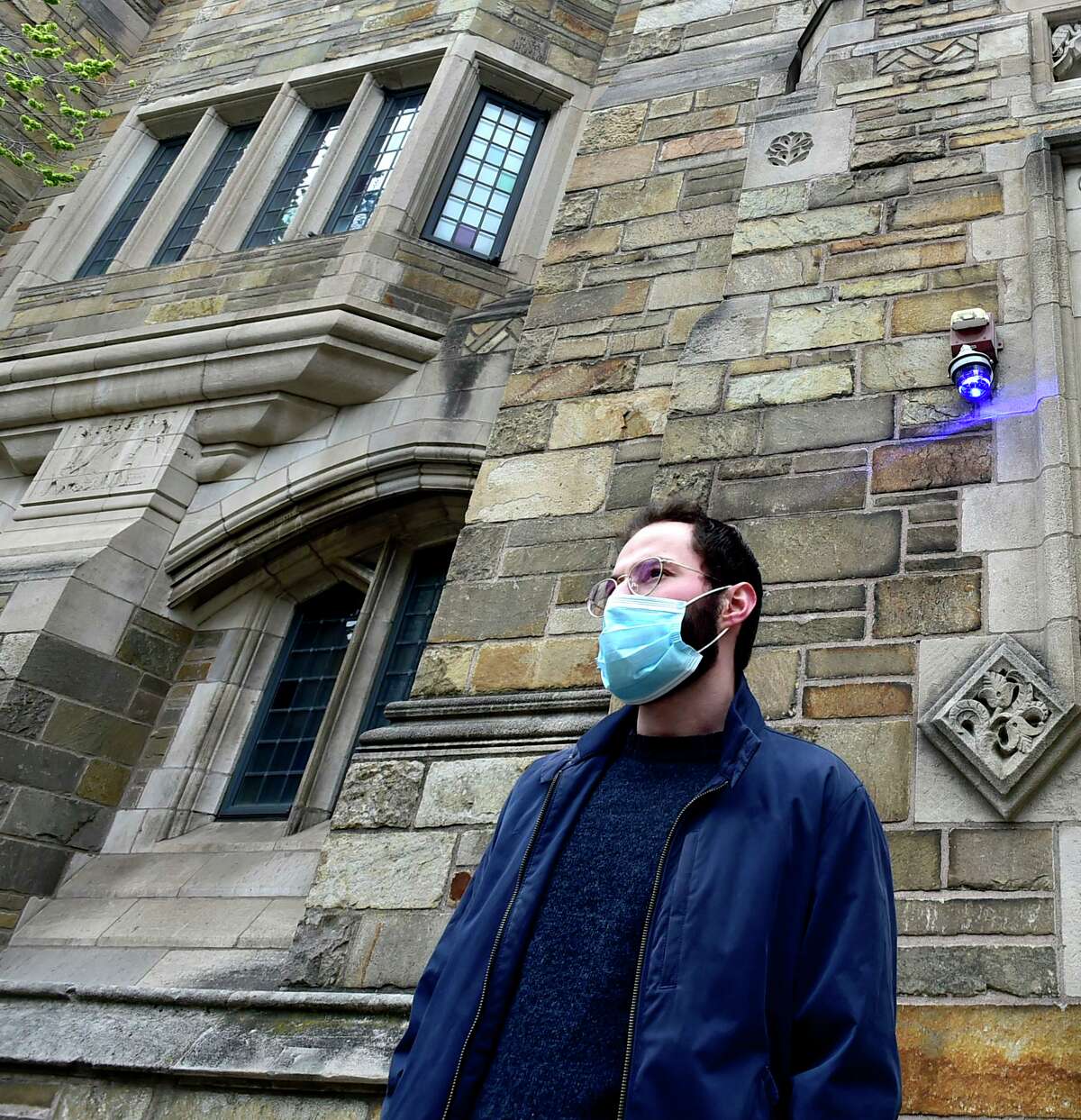 Not all students have left Yale University because of the Covid-19 / coronavirus pandemic. Here, Fatih Celikbas of Turkey, standing in front of Yale's Trumbull College. Celikbas, a fourth-year computer science major, still lives on the Yale University Campus. Students who can't go home because of various mitigating circumstance, are staying in Yale dorms, taking online classes.