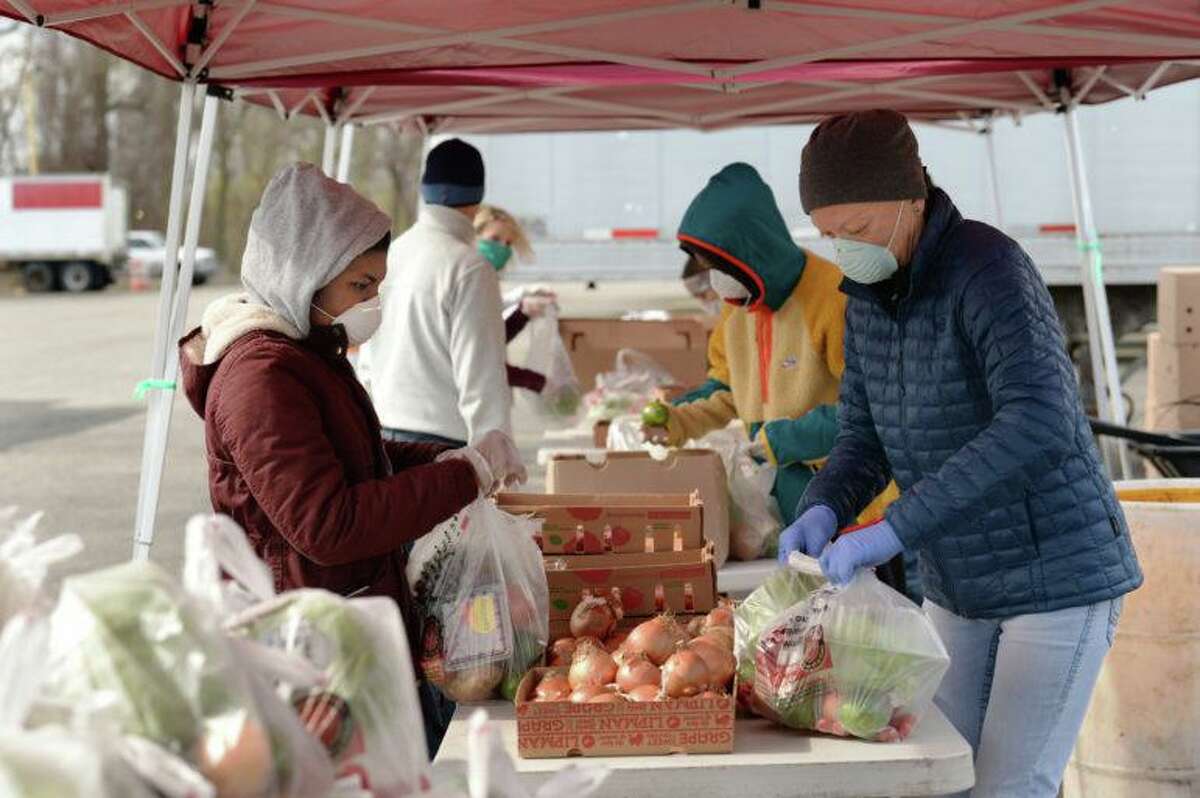 Volunteers package produce for pick up at Foodshare’s drive-through food pickup at the Hartford Regional Market.