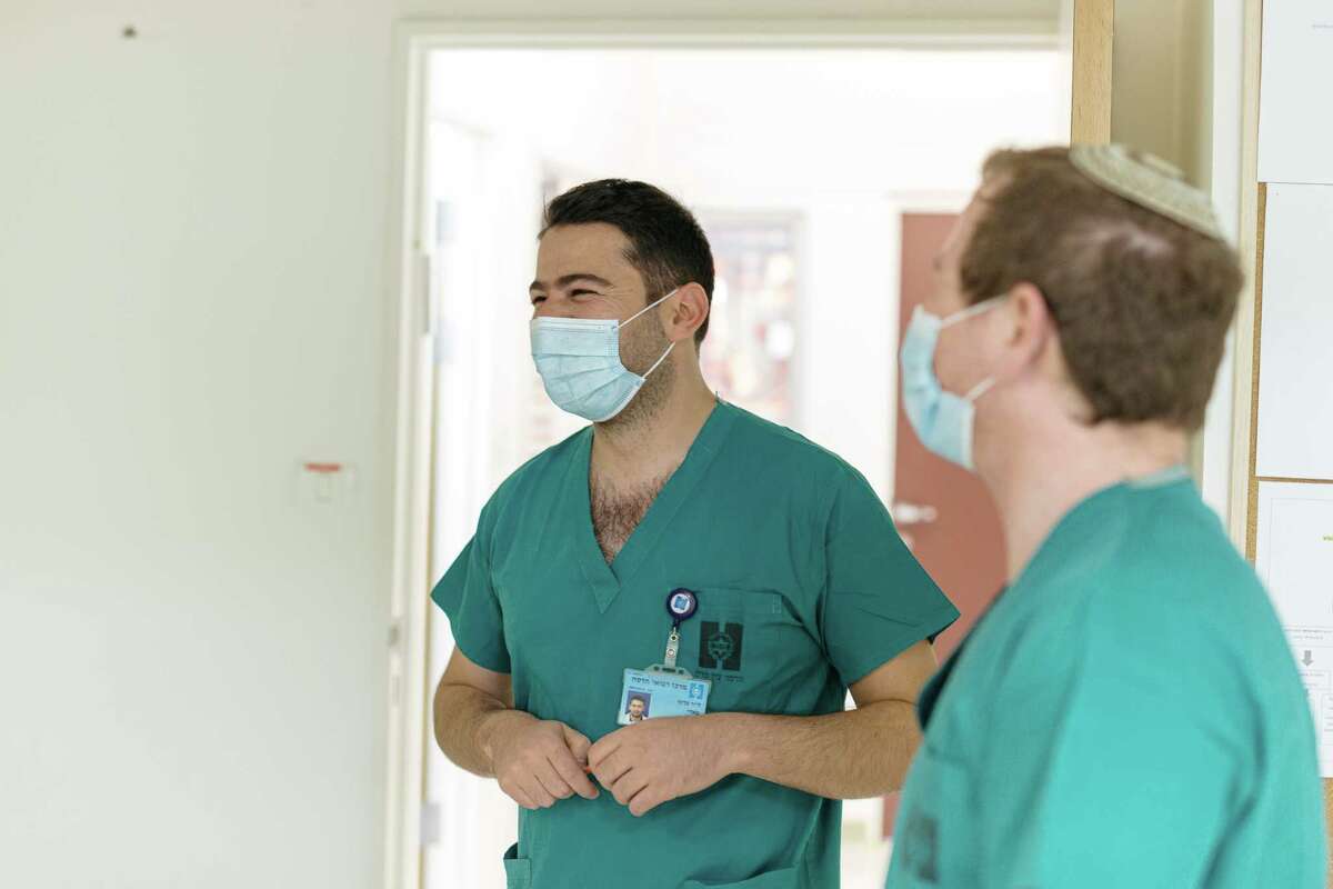 Doctors Fadi Kharouf, center, and Matan Fischer laugh during their shift at Hadassah Ein Kerem Hospital.