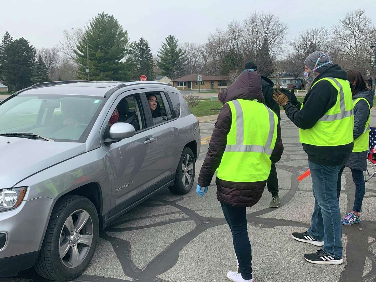 Volenteers from 242 Community Church handle food supplies donated to Hidden Harvest during a "drive-thru and drop off" food drive on Saturday, April 25, 2020 in the parking lot of Pat's Food Center in Freeland.