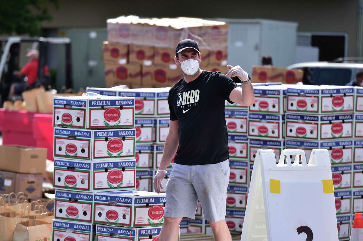 Chase Buford directs traffic during a food distribution event Saturday at the San Antonio Food Bank.