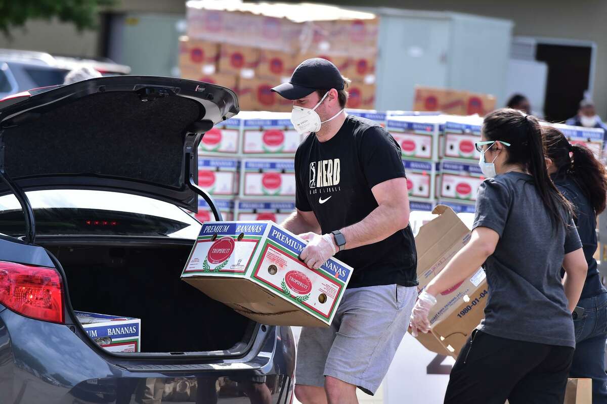 Chase Buford loads a car during a food distribution event Saturday at the San Antonio Food Bank.