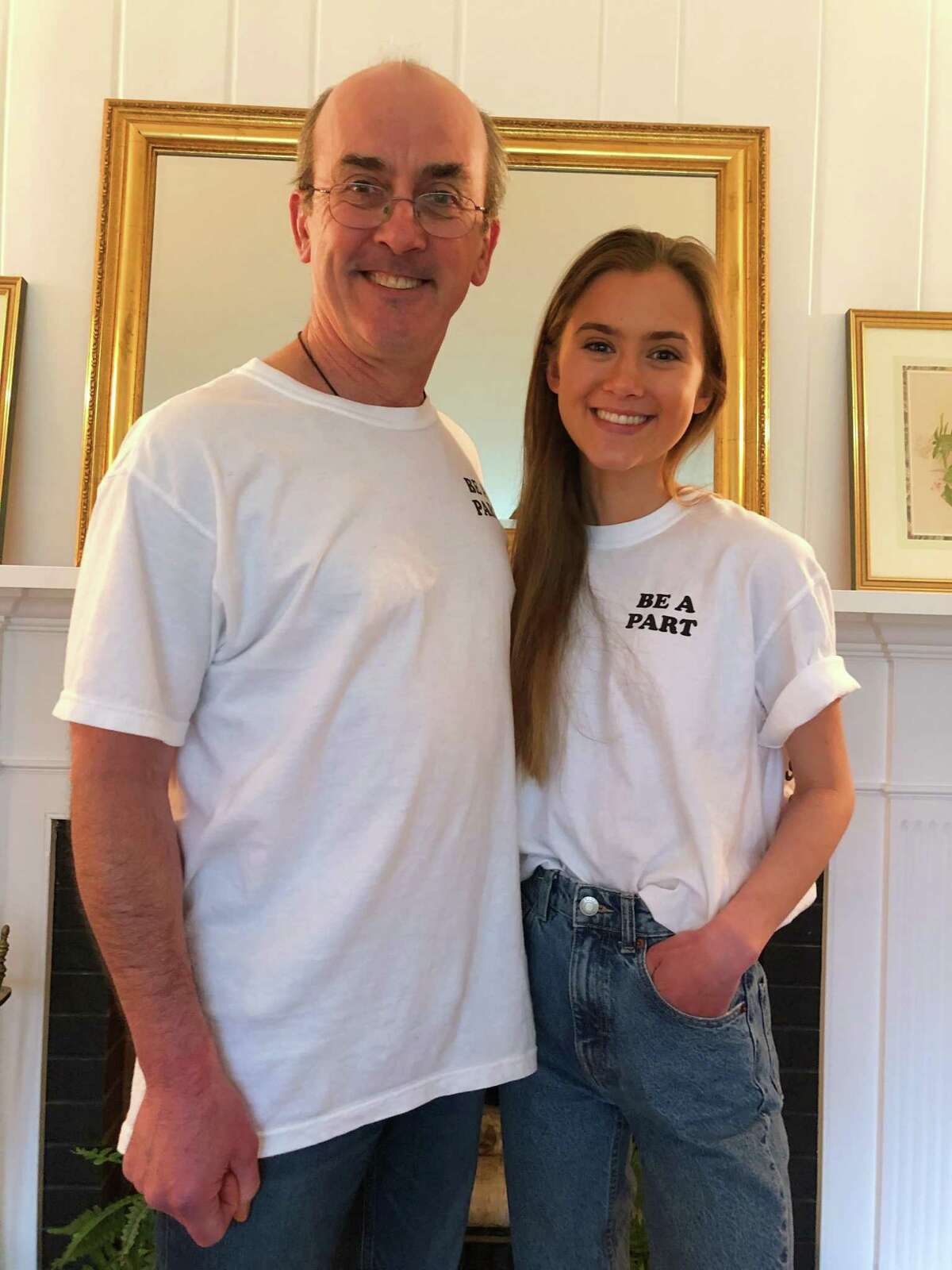 Margaux Kelley and her dad Brian wear the t-shirt she created to support local food banks.