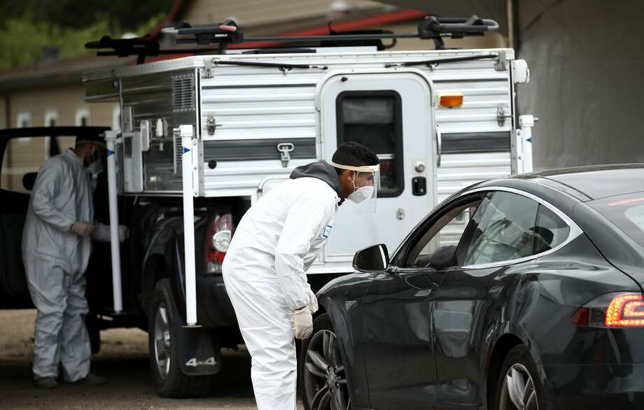 A medical professional administers a coronavirus (covid-19) test at a drive thru testing location conducted by staffers from University of California, San Francisco Medical Center (UCSF) in the parking lot of the Bolinas Fire Department April 20, 2020 in Bolinas, California. The town of Bolinas, with a population of 1600, is attempting to test the entire town for COVID-19. The test had two components - the first is a blood test that will look for antibodies, and the second is a mouth and throat swab that can detect active coronavirus infections. Photo: Ezra Shaw/Getty Images / 2020 Getty Images