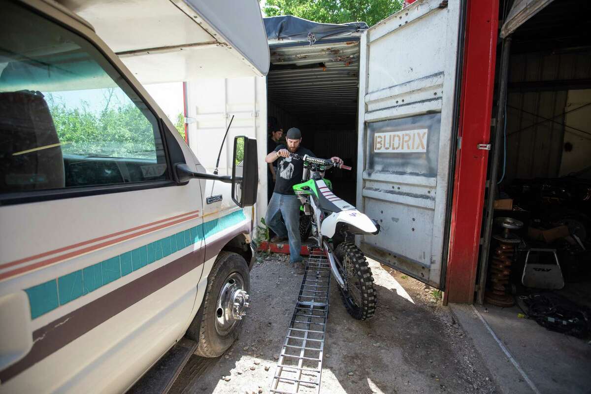 Bud Allen removes client motorcycles that must be sold or reclaimed before closing his business on Friday, April 24, 2020 in Buda, Texas.