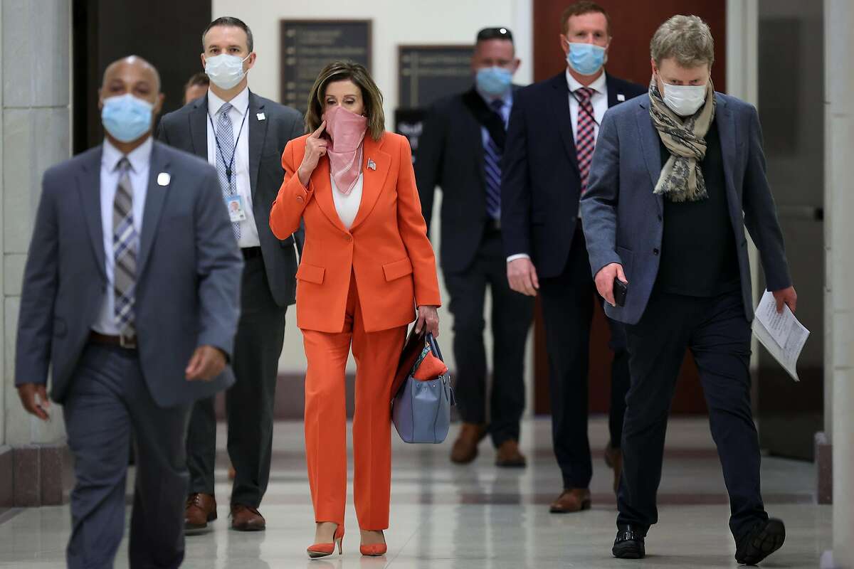 WASHINGTON, DC - APRIL 24: Wearing a scarf over her mouth and nose, Speaker of the House Nancy Pelosi (D-CA) is surrounded by security and staff as she arrives for her weekly news conference during the novel coronavirus pandemic at the U.S. Capitol April 24, 2020 in Washington, DC. President Donald Trump is expected to sign a bipartisan $484 billion coronavirus relief package to restart a depleted small business loan program and to provide funds for hospitals and COVID-19 testing. (Photo by Chip Somodevilla/Getty Images) *** BESTPIX ***