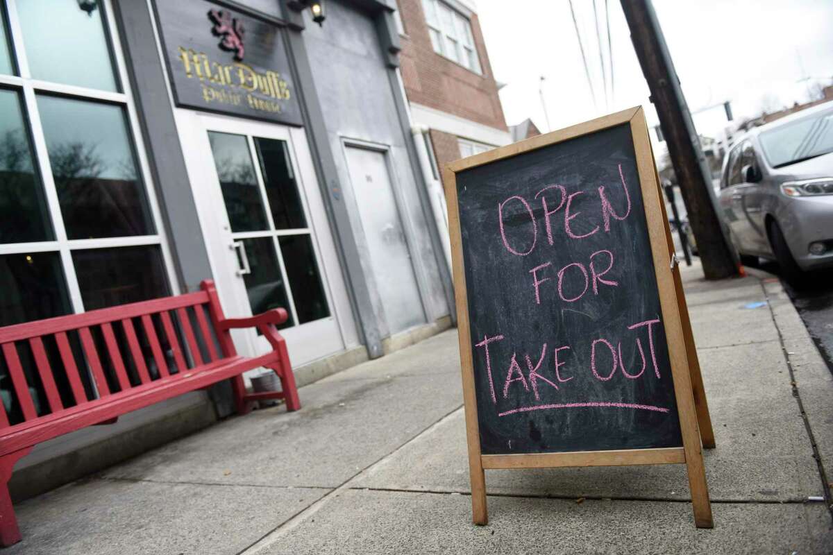 A sign is displayed that MacDuff's Public House is open for take out orders in Greenwich, Conn. Thursday, March 19, 2020. Restaurant dining rooms are closed amidst the coronavirus situation, but takeout and delivery are still options.