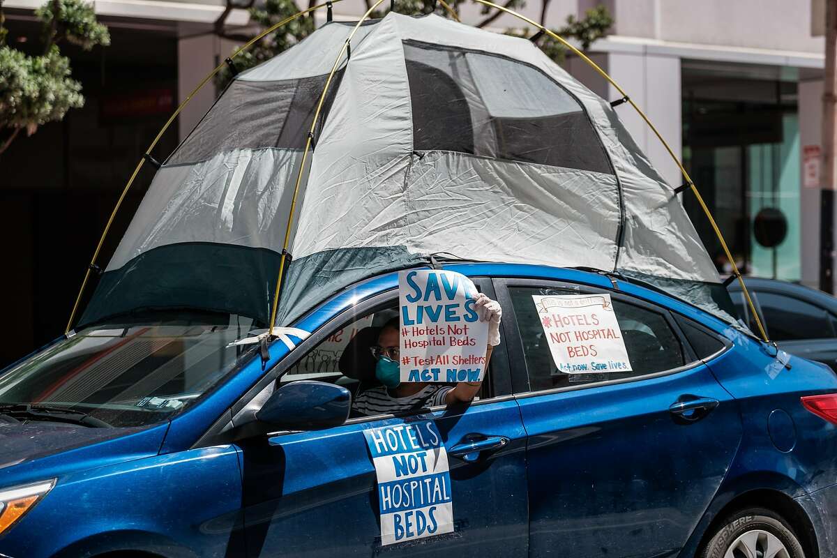A car convoy of about 50 drives by the Moscone Center to demand shelter for the homeless in San Francisco, Calif. on Monday April 13, 2020.
