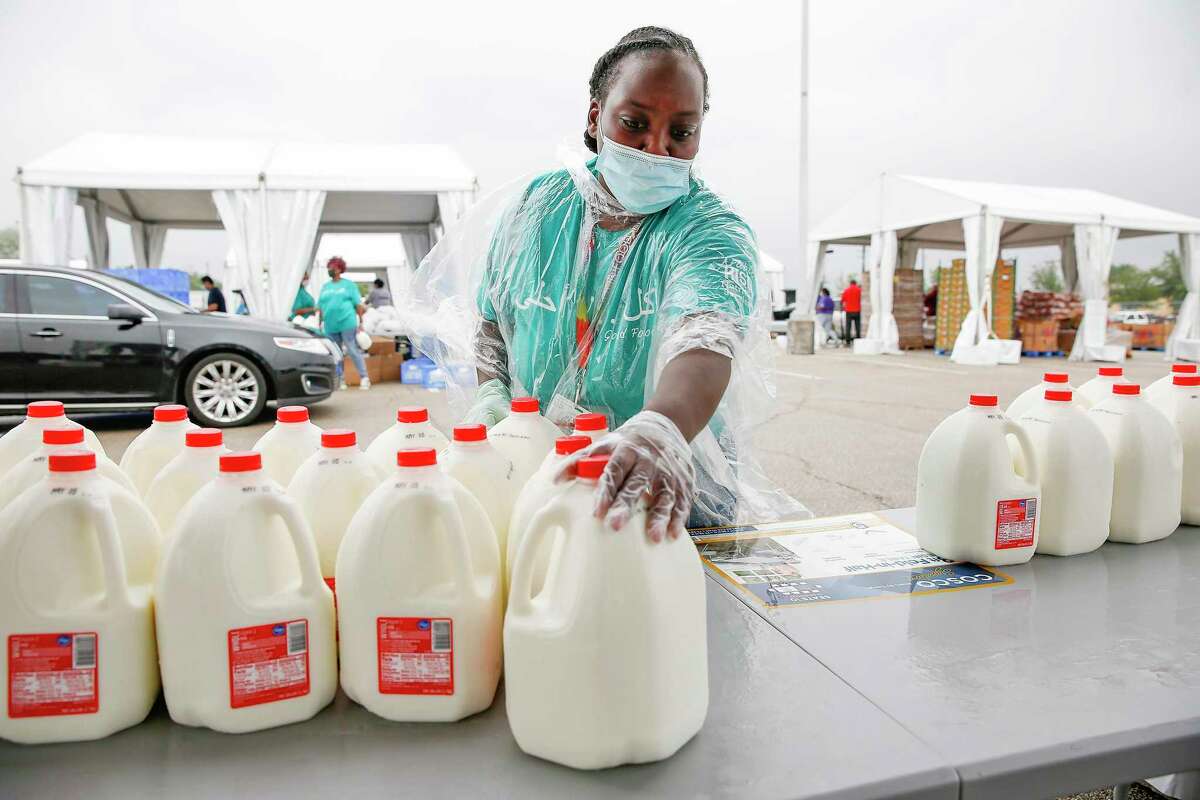 Houston Food Bank volunteer Rachel Hunt distributes milk at a mass distribution site sponsored by the food bank and the Houston Independent School District in the parking lot of NRG Stadium in Houston on Saturday, April 18, 2020.