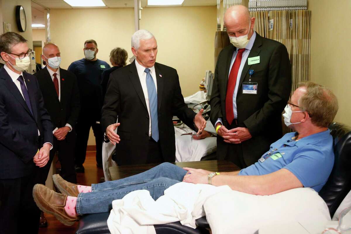 Vice President Mike Pence, center, visits a patient who survived the coronavirus and was going to give blood during a tour of the Mayo Clinic Tuesday, April 28, 2020, in Rochester, Minn., as he toured the facilities supporting COVID-19 research and treatment. Pence chose not to wear a face mask while touring the Mayo Clinic in Minnesota. It's an apparent violation of the world-renowned medical center's policy requiring them.