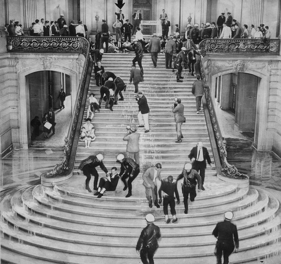 Police using fire hoses force demonstrators to clear the main stairway inside City Hall during the HUAC hearings.