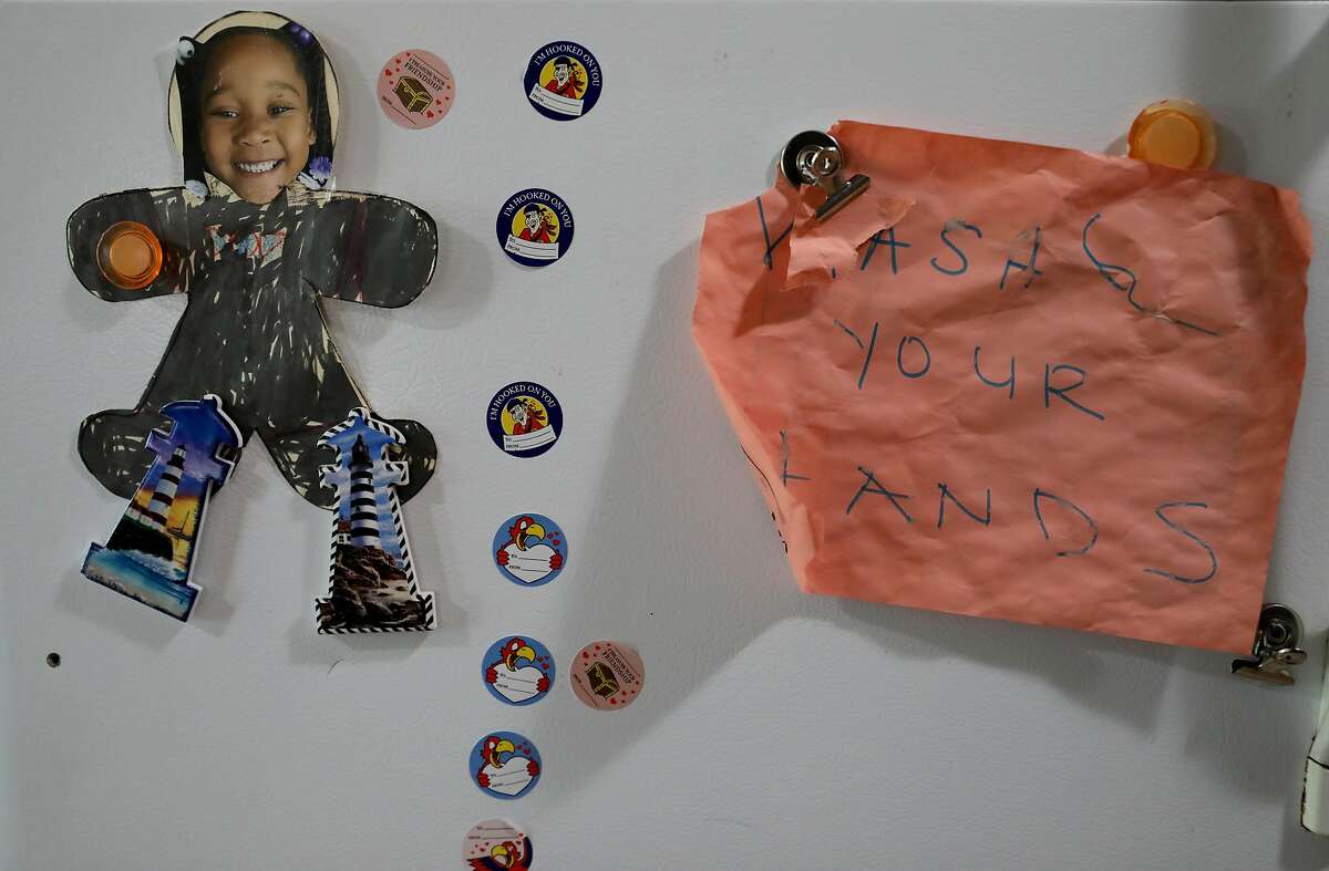 A photo of Kenya Pierce's daughter is displayed on the refrigerator along side a note stating, "Wash Your Hands," in their home on Tuesday, April 28, 2020, in Richmond, Calif. Pierce, who formally worked for WIC for nine years, is currently receiving WIC benefits.