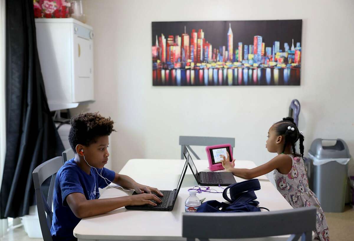 Kenya Pierce's children Dannon Lemon, 12, and Nairobi Banks, 7, quietly work at their table in their home on Tuesday, April 28, 2020, in Richmond, Calif. Pierce, who formally worked for WIC for nine years, is currently receiving WIC benefits.