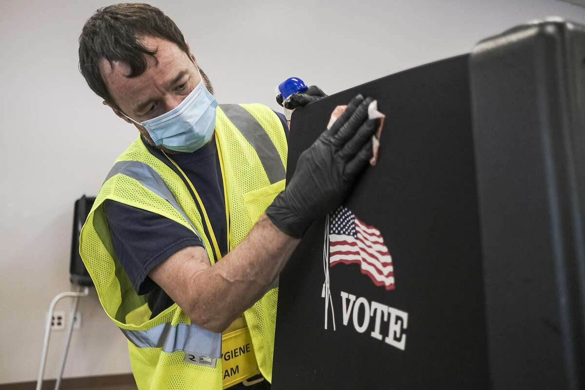 A worker sanitizes voting stations in Columbus, Ohio, on April 28, 2020.