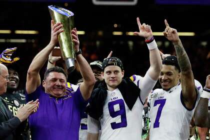 LSU coach Ed Orgeron, left, celebrates January’s victory over Clemson in the national championship game with quarterback Joe Burrow (9) and safety Grant Delpit(7), who were among the 14 Tigers selected in last week’s NFL draft.