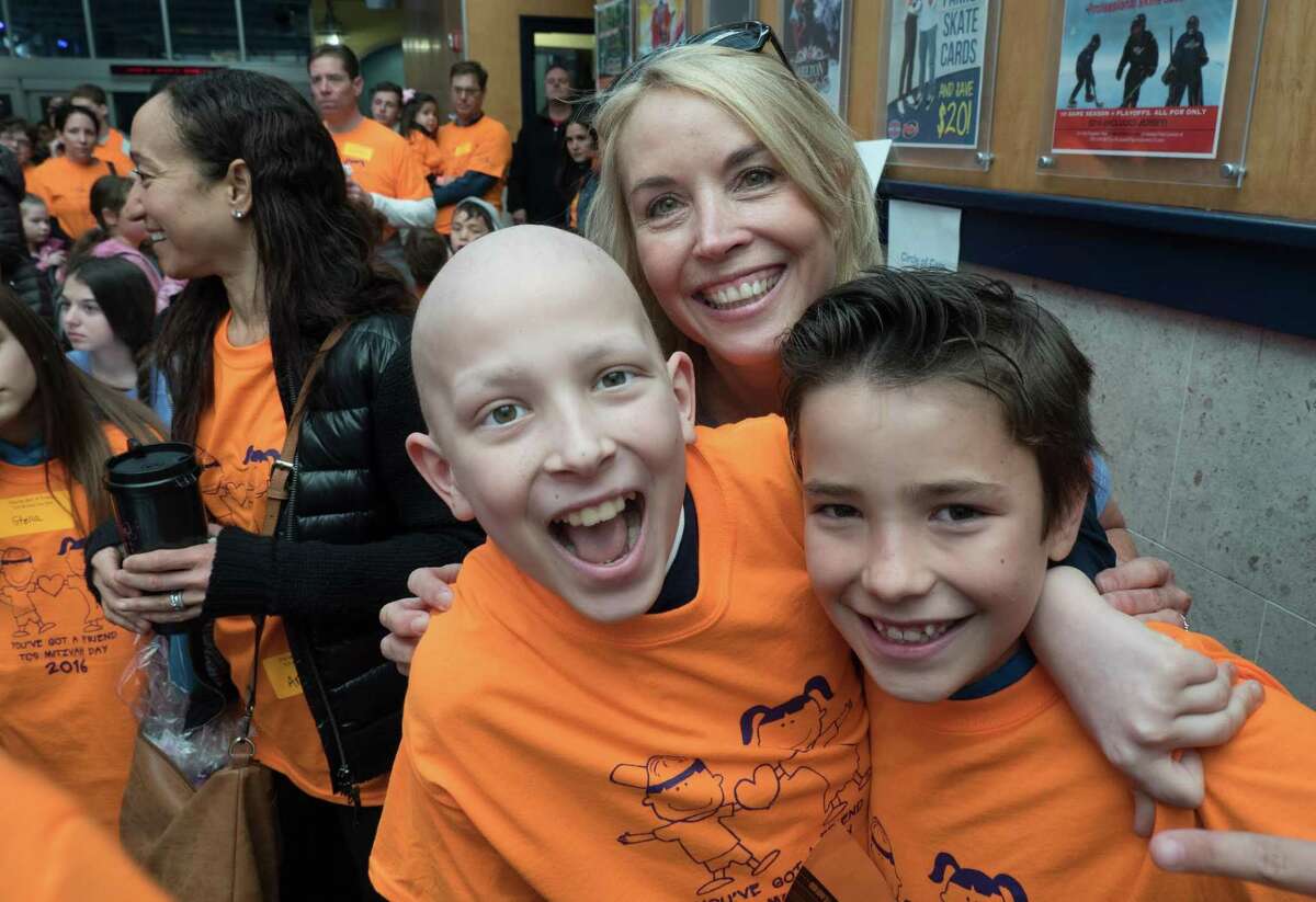 Circle of Care is the beneficiary of the annual Sip 'N' Shop event taking place this month. Above, co-founder Liz Salguero is joined by two children the organization has helped, either through financial donations, emotional support, or social activities.