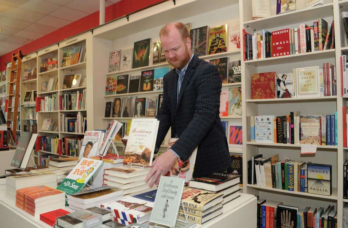 Brazos Book Store General Manager Jeremy Ellis arranged the books on the display table.