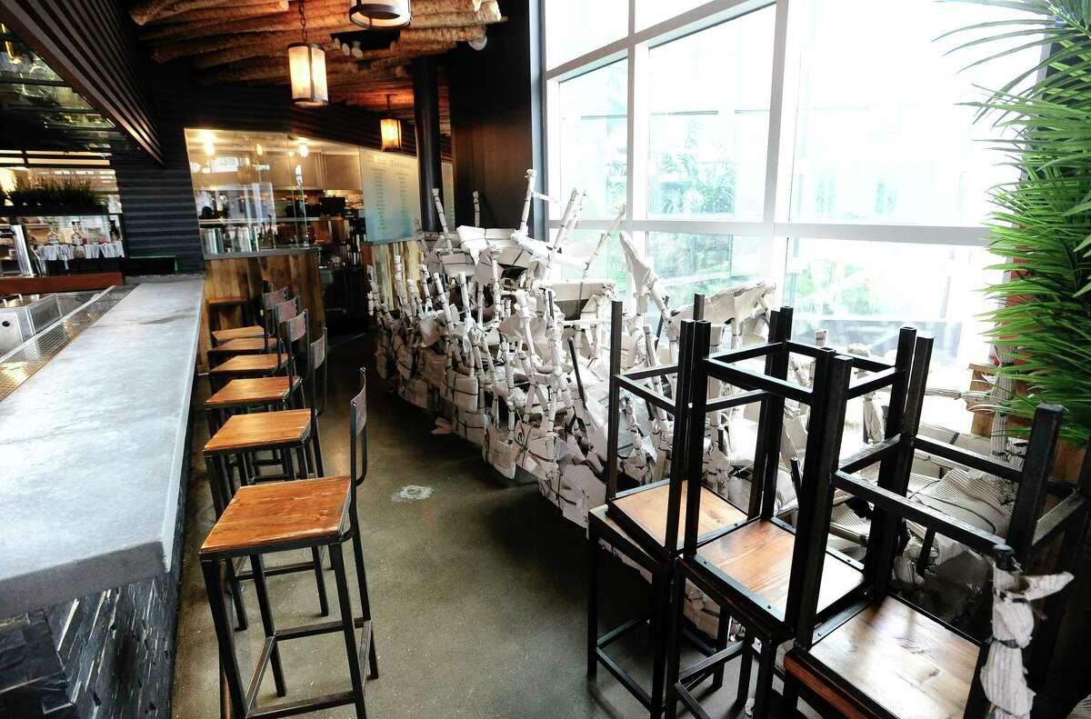 Chairs are stacked up at Mexicue restaurant in Stamford, Connecticut on April 29, 2020. The kitchen is busy preparing to go orders for customers living in Stamford's Harbor Point community. Several area restaurants like Mexicue, in response to the COVID-19 pandemic, have had to reinvent how they serve their customers and do business. Changing up menus, creating an online and social media presence. Mexicue has served over 350 meals weekly, as well as providing meals for frontline responders.