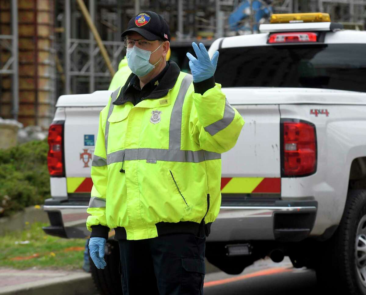 A Stamford police officer directs traffic while wearing a mask and gloves along Washington Blvd. on April 8, 2020 in Stamford, Connecticut. The city is testing all police officers and other first responders for coronavirus, whether they are showing symptoms or not.