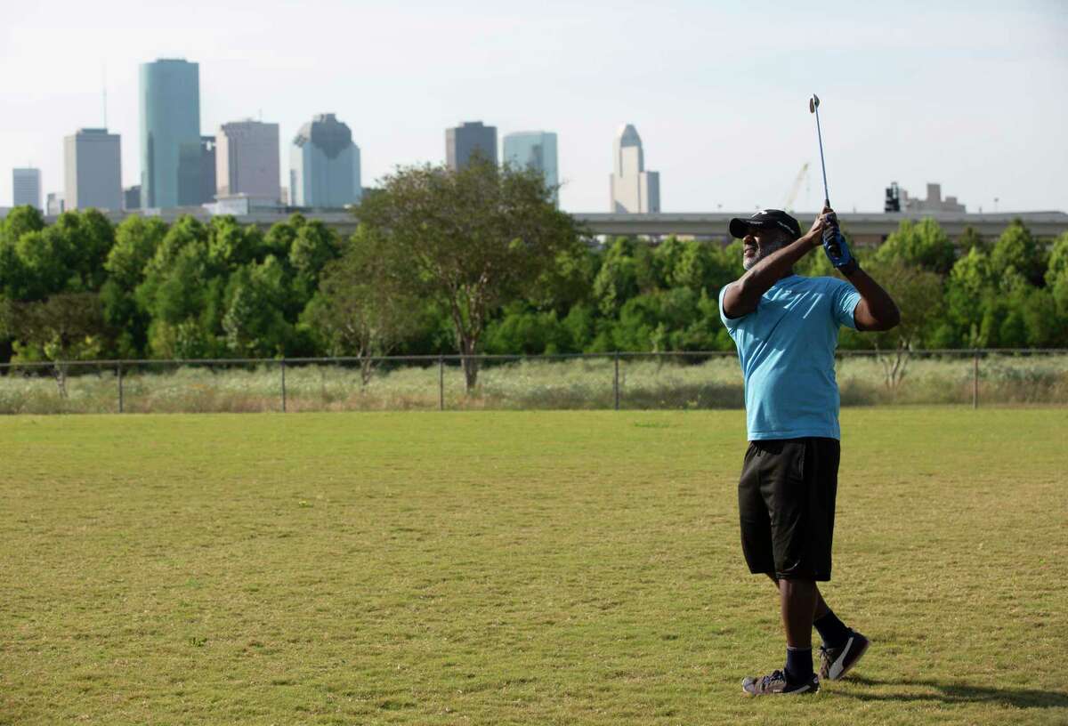 Claude Milsap Jr. practices his golf swing at a baseball field on April 27, 2020, at Stude Park in Houston. Milsap, who used to go practice at a golf course after work, has been practicing his swings at the field every morning before work since the coronavirus outbreak.