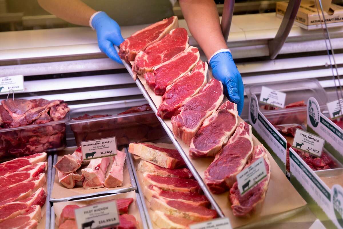A butcher lays out fresh cuts of steak at Marin Sun Farms Butcher Shop in Oakland, Calif. Wednesday, April 29, 2020. Many meat processing plants in the midwest have had to close due to outbreaks of the virus among workers, and now President Trump has ordered that meat plants remain open. But smaller, artisanal meat producers like Marin Sun Farms are in much better shape, with an intact supply chain that can still get meat to local customers.