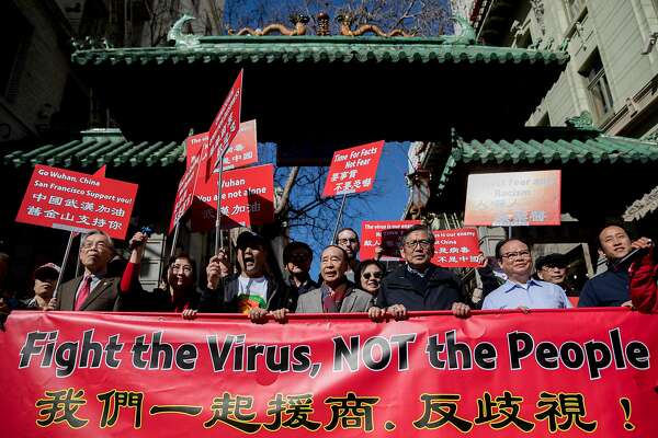 Protesters walk through the Dragon Gate in S.F.’s Chinatown during a February protest coronavirus-fueled racism against Chinese Americans.