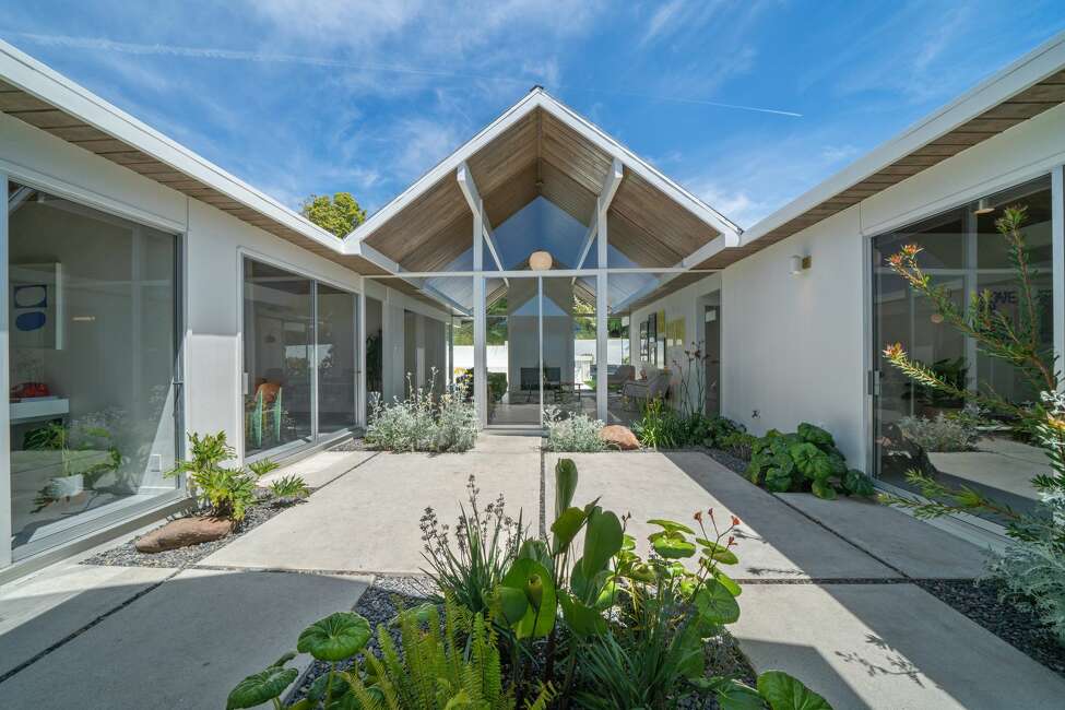 Many Eichlers are built around courtyards or atriums, and this one is no different, with separate wings of the house facing this central open space though glass walls.