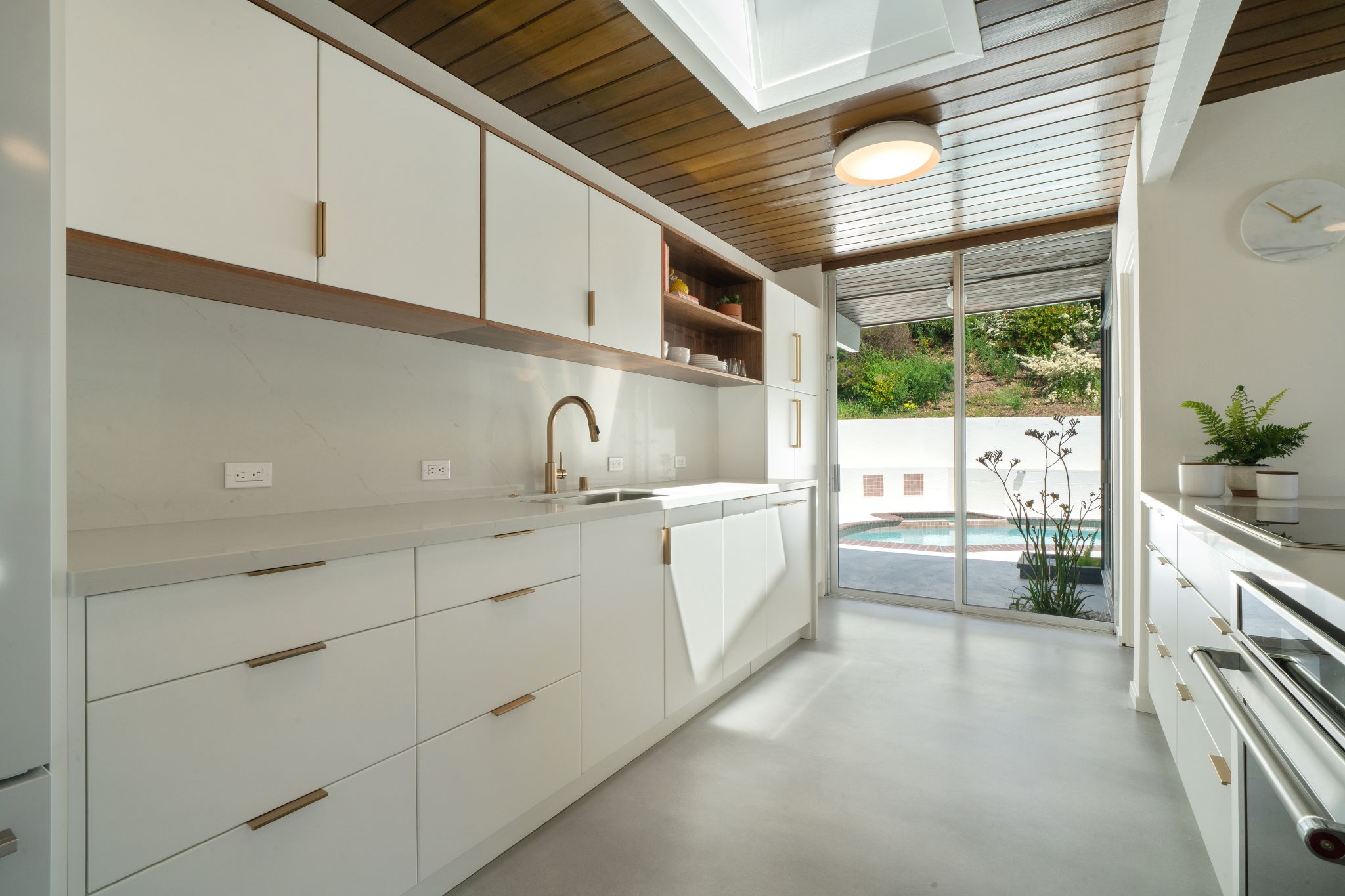 With a mid-century vibe, the kitchen is of today's century: quartz countertops, Columbia walnut and white custom cabinets, and the latest in KitchenAid appliances.