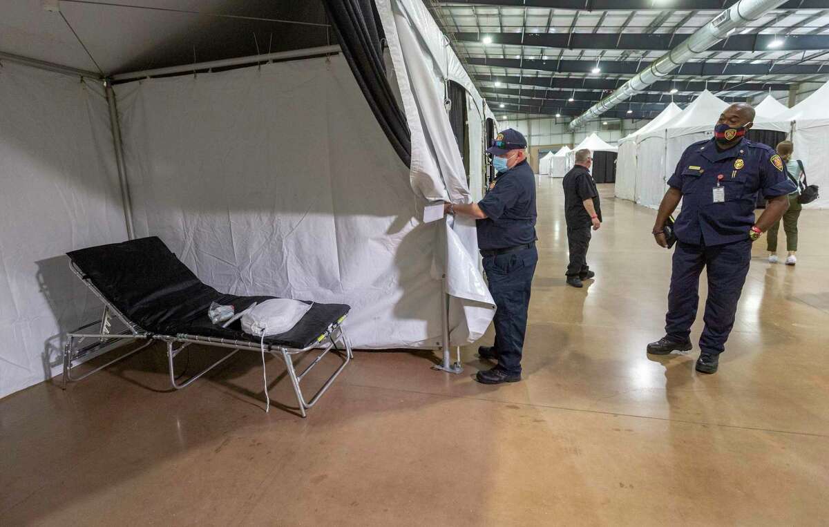 San Antonio Fire Department chief Charles Hood, right, looks Wednesday at one of the beds in the alternate care facility that has been built inside the Expo Hall on the grounds of the AT&T Center and Freeman Coliseum. The facility, which currently has 80 beds but could expand, was built to provide extra bed space for people with medical needs if area hospitals were overwhelmed with COVID-19 patients. But it hasn’t been needed.