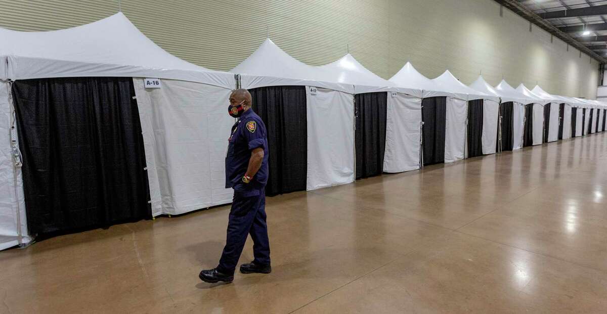 Fire Chief Charles Hood walks through the care facility built inside the Expo Hall on the grounds of the AT&T Center and Freeman Coliseum. The facility, which currently has 80 beds but could expand, was built to provide extra bed space for people with medical needs if area hospitals were overwhelmed with COVID-19 patients. But it hasn’t been needed.