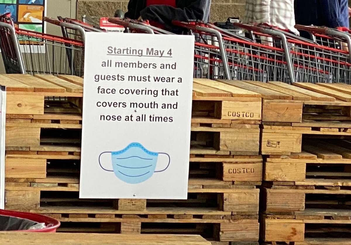 A face covering sign posted at the 4th Avenue Costco warehouse in Seattle, Washington on April 29, 20202. Starting on May 4, all guests "must wear a mask or face covering that covers the mouth and nose at all times while at Costco," according to a post on the company's web page.