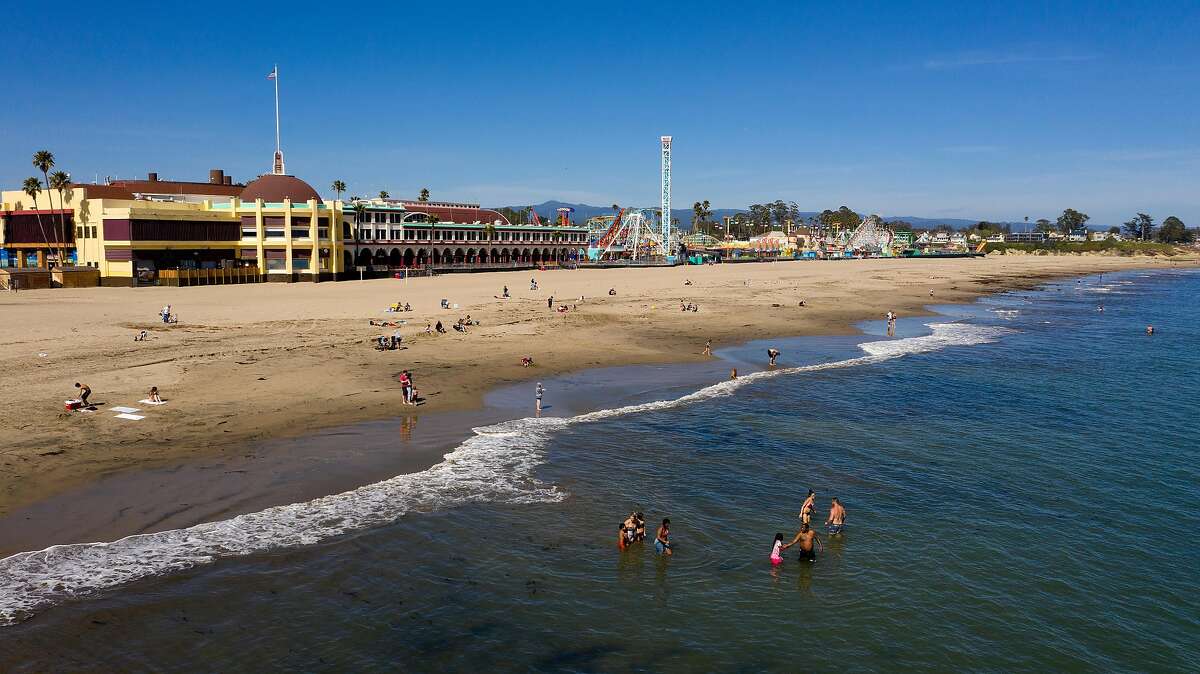 2020年4月22日星期三，游泳者在加利福尼亚州圣克鲁斯海滩游泳。