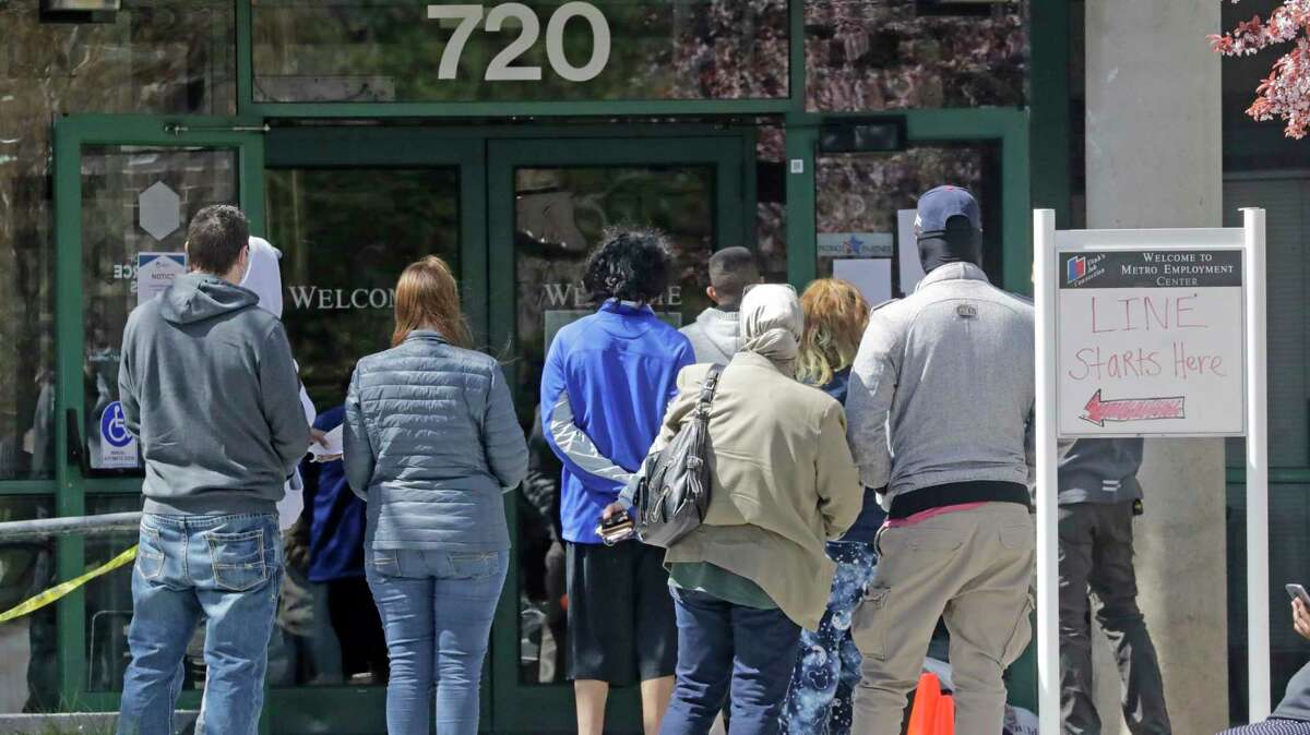 People wait at the Utah Department of Workforce Services. The focus on individual wealth and business efficiency has led to many living paycheck to check, and to a shortage of products.