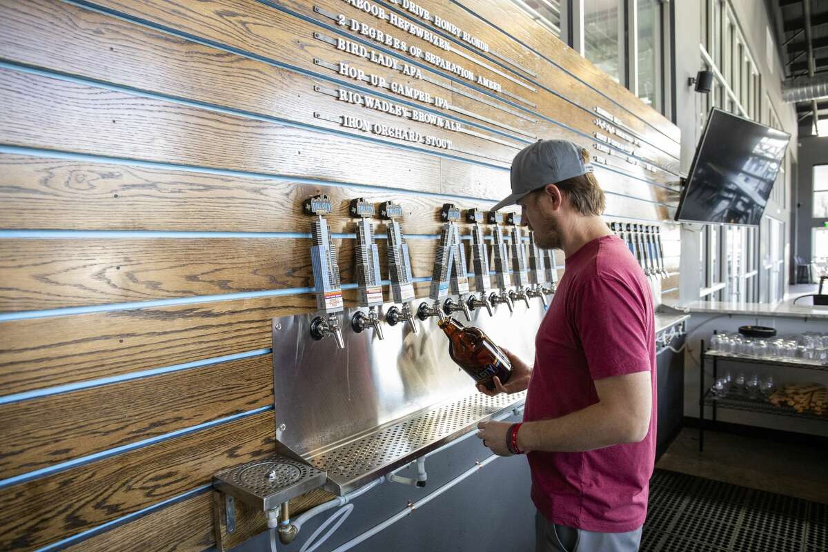 Co-founder Jeff Thomas fills growlers on Thursday, April 20, 2020 at Tall City Brewing Co.