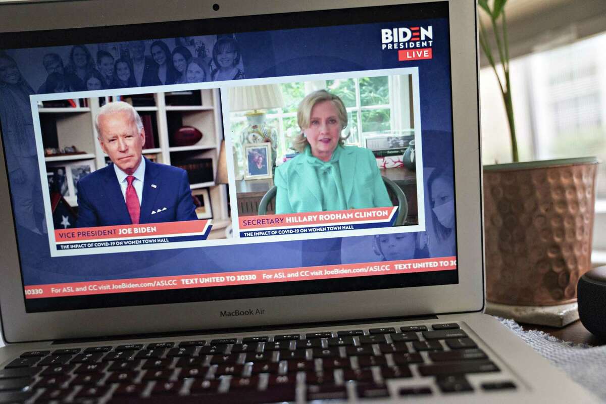 Hillary Clinton, former U.S. secretary of state, right, speaks as former Vice President Joe Biden, presumptive Democratic presidential nominee, listens during a virtual event seen on a laptop computer in Arlington, Virginia, U.S., on Tuesday, April 28, 2020. Clinton endorsed Biden today saying that she wishes he were in the White House to lead the country through the coronavirus pandemic. Photographer: Andrew Harrer/Bloomberg