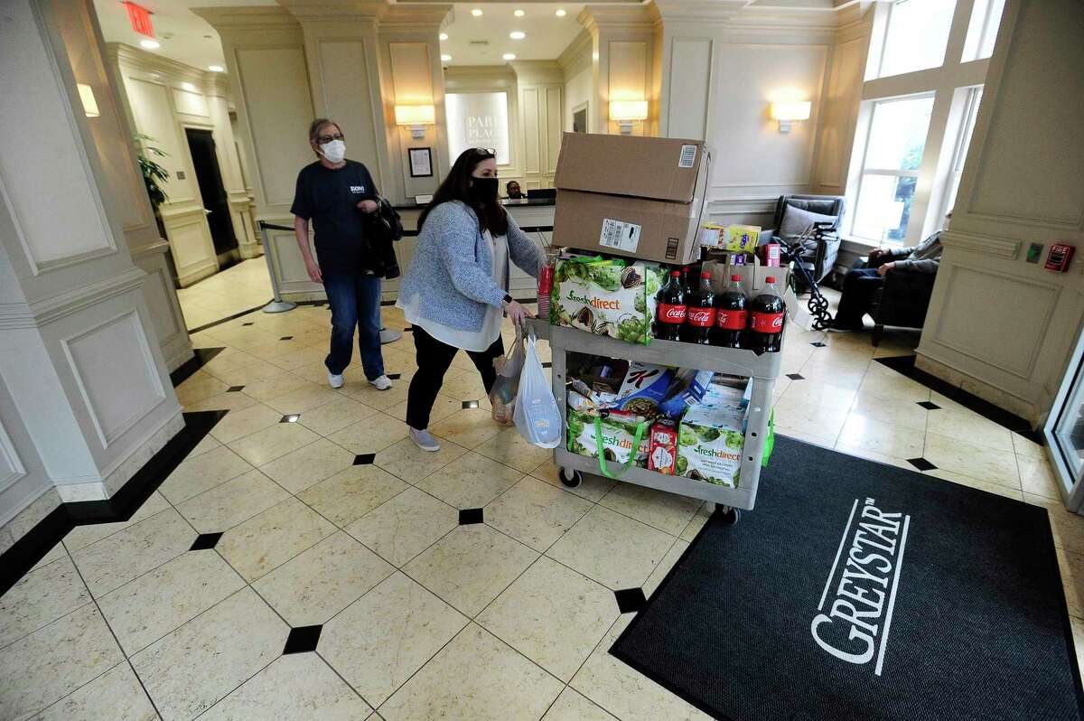 Resident Janice Richman watches as Danielle Burrows, Community Manager at Park Place, push a cart of food items collected by residents. Residents of 101 Park Place at Harbor Point on Washington Boulevard in Stamford, Connecticut donated non-perishable food items to a local food pantry on Thursday, April 30, 2020. CORT Furniture Rental, a vendor of 101 Park Place delivered the donation to Connecticut Food Bank in Wallingford, who has partnered with Move for Hunger to distribute several local food pantries through out the area.