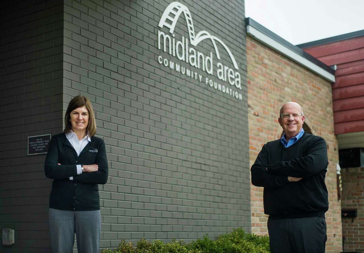 Sharon Mortensen, president and CEO of the Midland Area Community Foundation, left, and Duncan Stuart, board chair, right, pose for a portrait Thursday in front of the MACF. (Katy Kildee/kkildee@mdn.net)