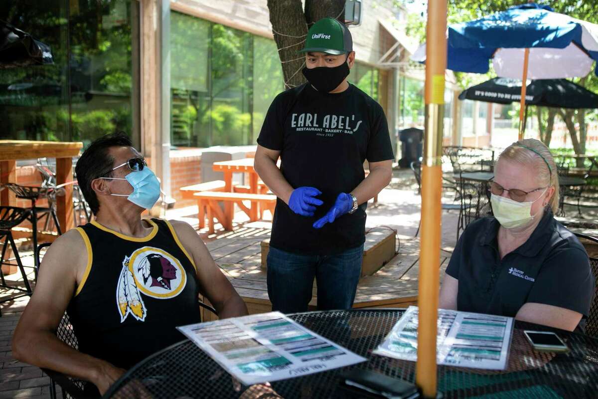 Danny Badiola takes orders from the first customers Ed and Laura Nasis at Earl Abel's on May 1. Earl Abel's is reopening for patio-only table service following restrictions on restaurants being lifted by Gov. Greg Abbott.