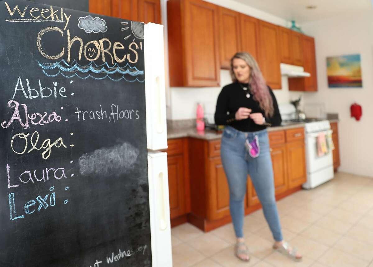 自2020年4月30日星期四在加利福尼亚州旧金山发布“居家令”以来，当室友搬到其他地方时，亚历克莎·刘易斯(Alexa Lewis)一直独自生活。左边冰箱侧面的黑板上可以看到最近过去房客的家务。