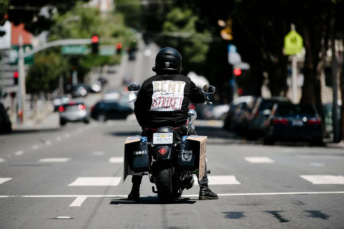 A person advocating for rent strikes sits at a stop light in San Francisco, Calif, on Friday, May 1, 2020.