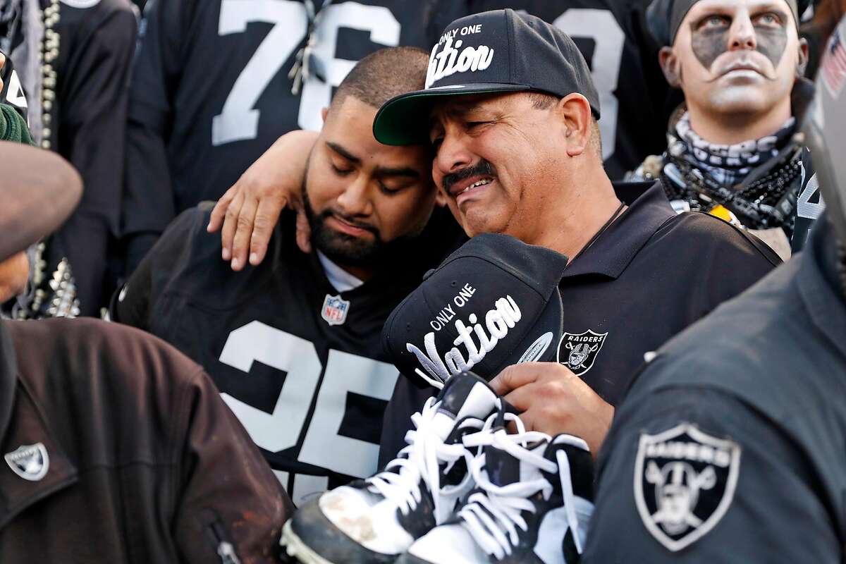 Oakland Raiders' fan Jesse Contrears cries as he hugs his son, Jesse, after Jacksonville Jaguars' 20-16 win during Raiders' final game at Oakland Coliseum in Oakland, Calif., on Sunday, December 15, 2019.