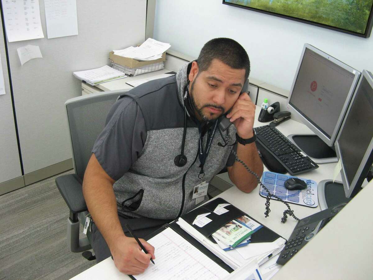 Carlos Alvarez, a nurse with Visiting Nurse & Hospice of Fairfield County, takes a call from a member of the community on April 1, 2020, as the nursing agency in Wilton, Conn., opens its Ask A Nurse hotline.